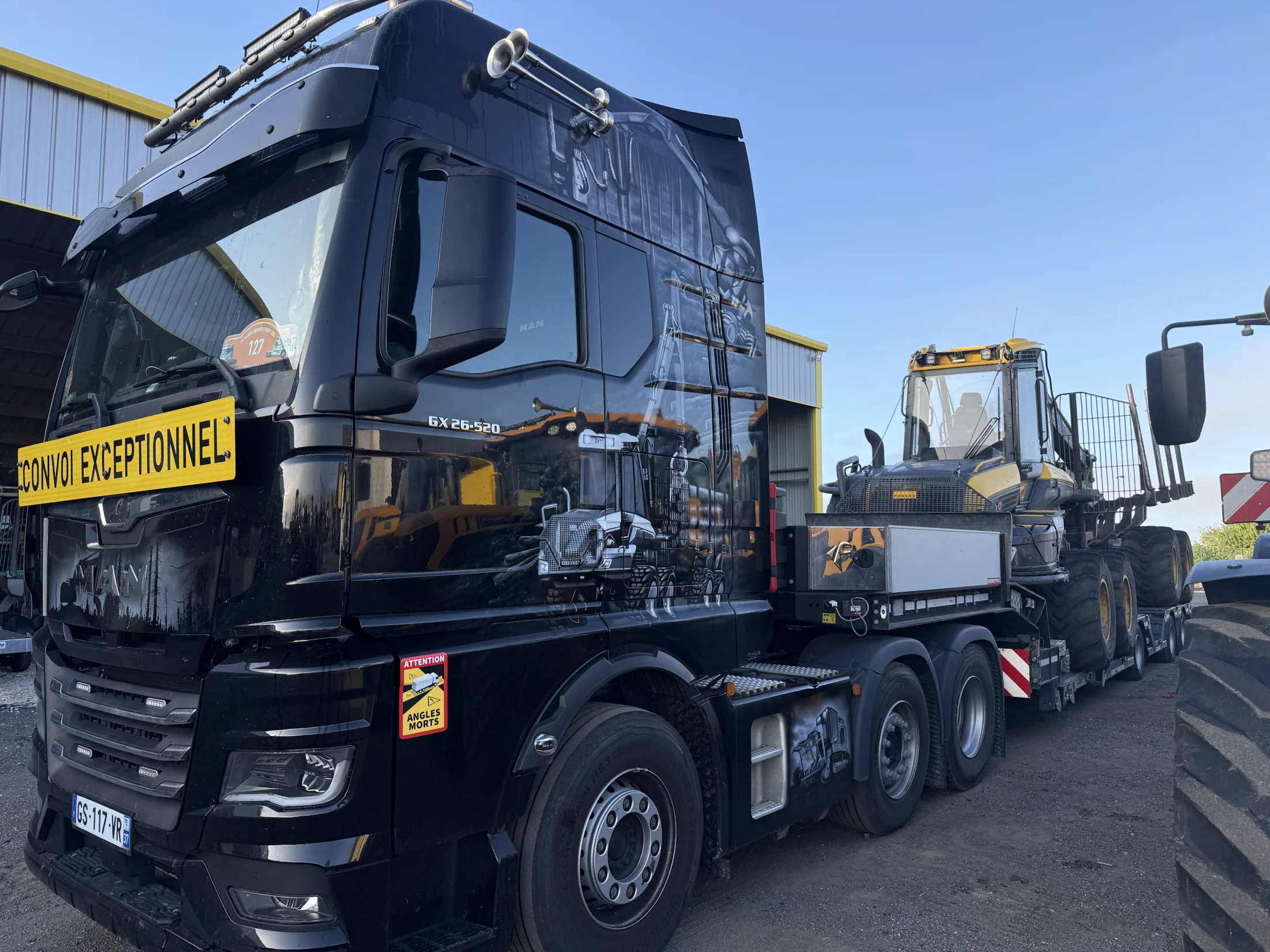 Camion DYNA transportant un porteur forestier